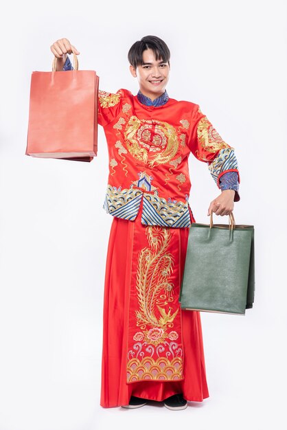 Man wear Cheongsam suit smile with paper bag from shopping in chinese new year
