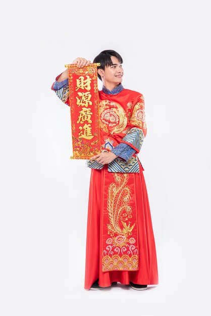 Man wear Cheongsam suit and wear black shoe give family the chinese greeting card for luck in chinese new year