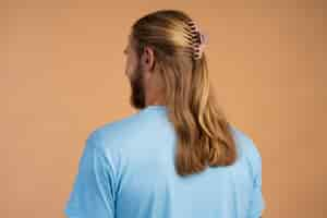 Free photo man wearing big hair clip side view