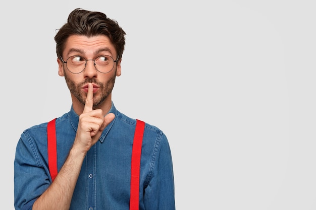 Man wearing denim shirt and red suspenders