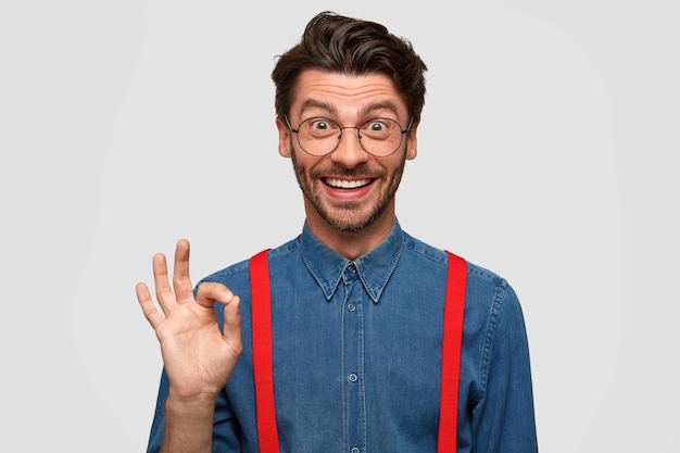 Man wearing denim shirt and red suspenders