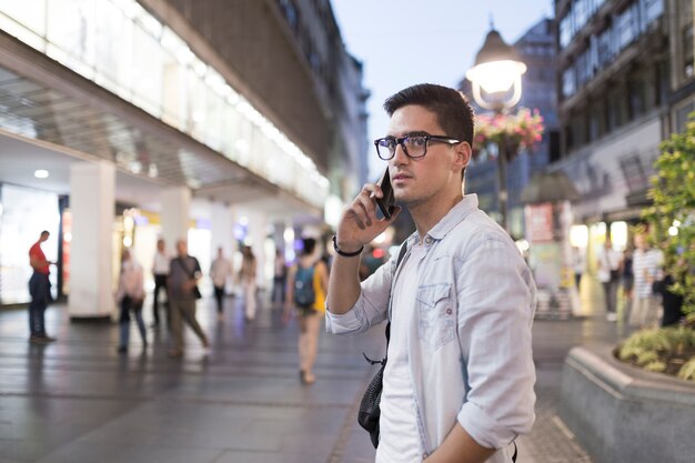Man wearing eyeglasses talking on mobile phone