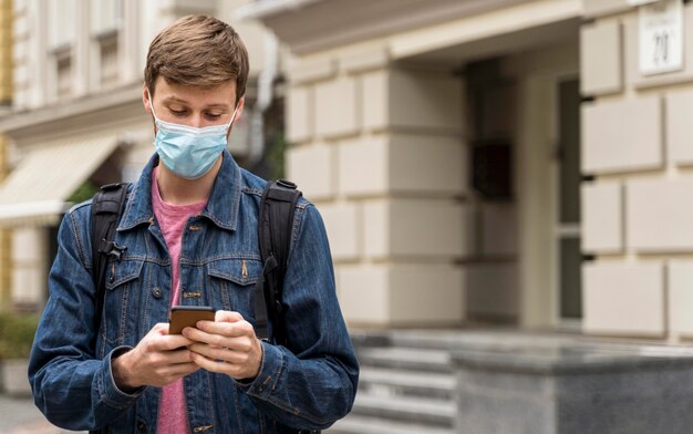 Man wearing a face mask outdoors with copy space