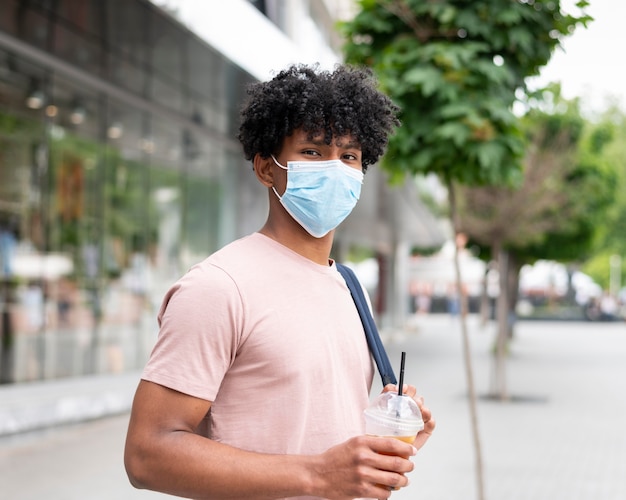 Free photo man wearing face mask outside