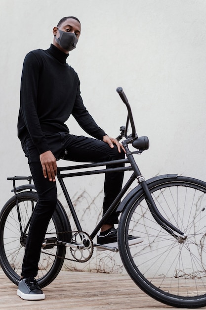 Man wearing facial mask and  riding his bike