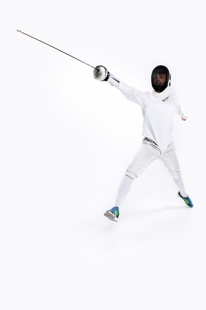 Free photo man wearing fencing suit practicing with sword against gray