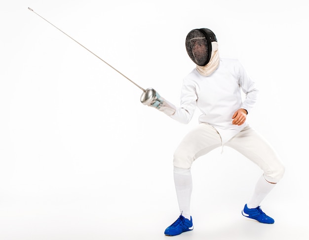 Free photo man wearing fencing suit practicing with sword against gray