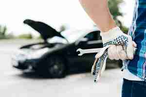 Free photo man wearing gloves holding wrench