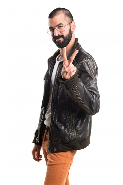 Man wearing a leather jacket doing victory gesture