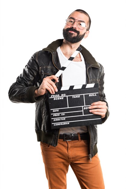 Man wearing a leather jacket holding a clapperboard