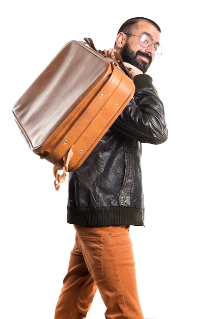 Free photo man wearing a leather jacket holding a suitcase