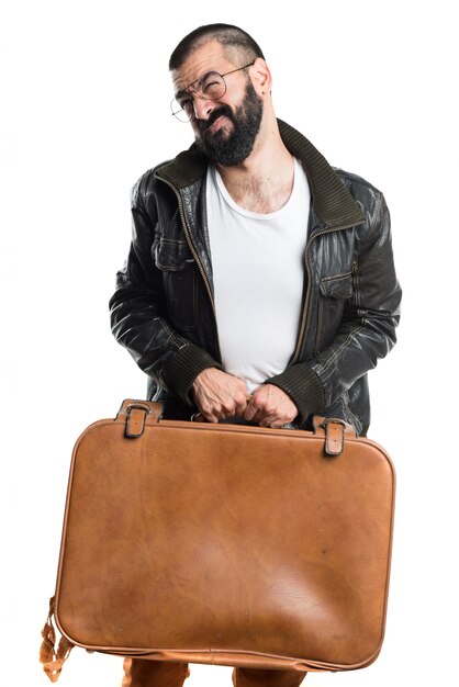 Man wearing a leather jacket holding a suitcase