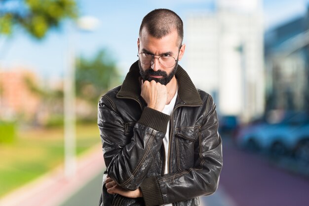 Man wearing a leather jacket thinking