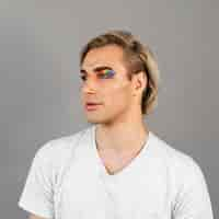 Free photo man wearing make-up cosmetics and looking away