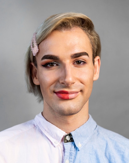Man wearing make-up on half his face and smiles