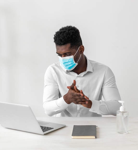 Man wearing mask and cleaning his hands