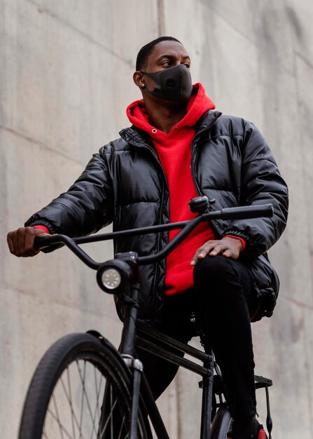 Man wearing a mask and riding his bike