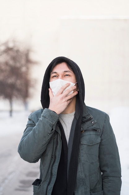 Man wearing medical mask outside with copy space