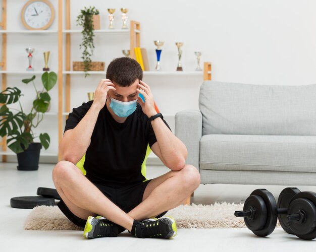Человек, носящий медицинскую маску во время ношения спортивной одежды