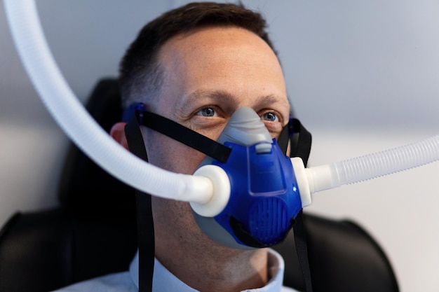 Man wearing oxygen mask during treatment in hyperbaric chamber