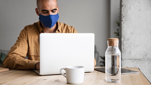 Foto gratuita uomo che indossa la maschera di protezione al chiuso