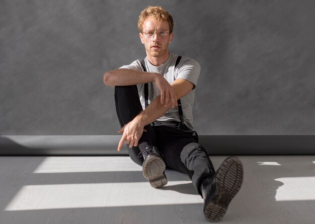 Man wearing reading glasses sitting on the floor