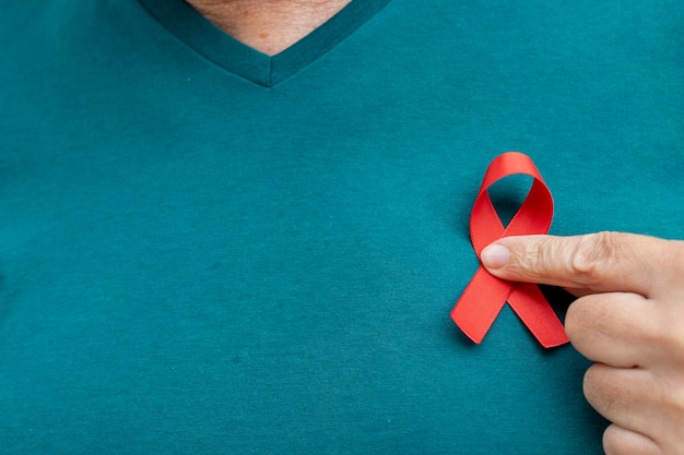 Man wearing a red aids awareness ribbon on his chest world aids day and world diabetes day