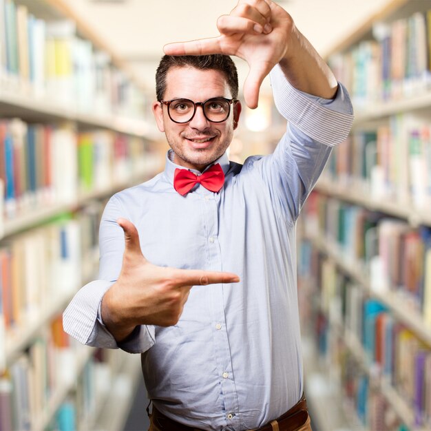 Man wearing a red bow tie. Doing a frame with his hands.