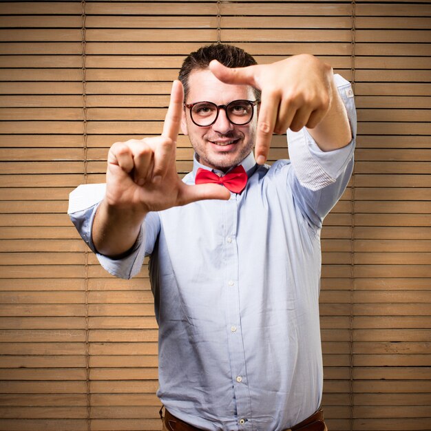 Man wearing a red bow tie. Doing a frame with his hands.