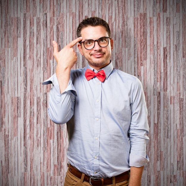 Man wearing a red bow tie. Doing a gun gesture.