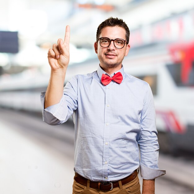 Man wearing a red bow tie. Doing one number gesture.