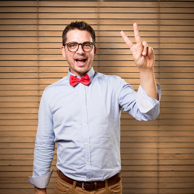 Free photo man wearing a red bow tie. doing victory gesture.