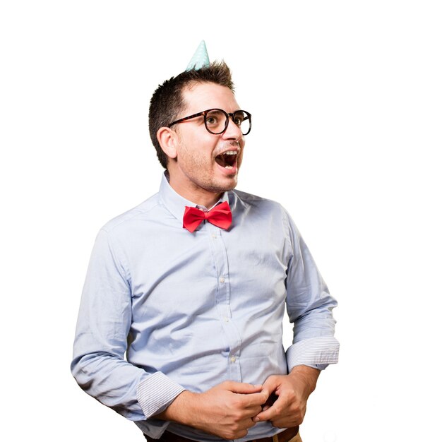 Man wearing a red bow tie and party hat. Looking surprised.