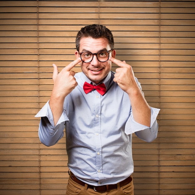 Man wearing a red bow tie. Pointing to his eyes.