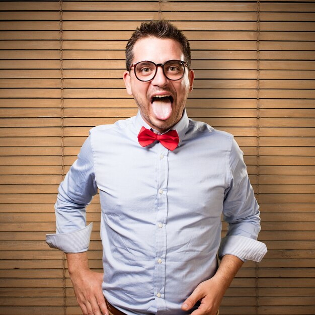 Man wearing a red bow tie. Pulling his tongue out.