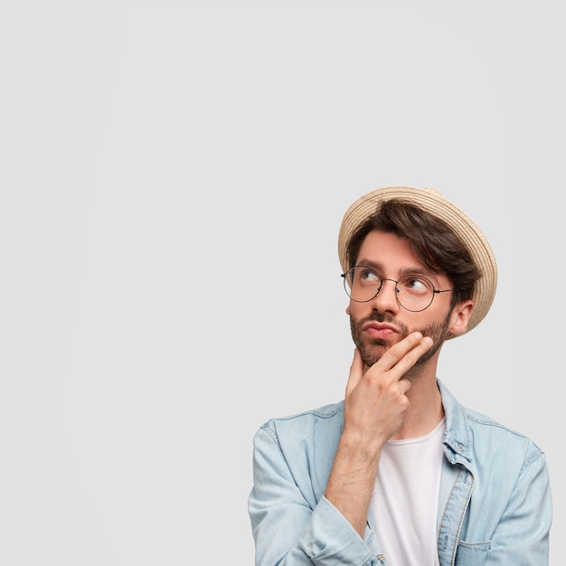 Man wearing straw hat and denim shirt