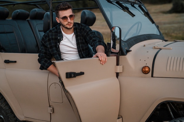 Man wearing sunglasses and traveling alone by car