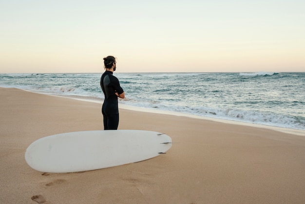 Man wearing surfer clothes watching the sunrise