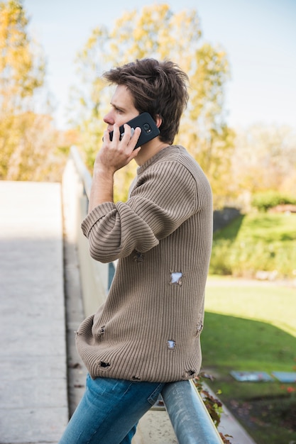 Man wearing sweatshirt talking on cell phone