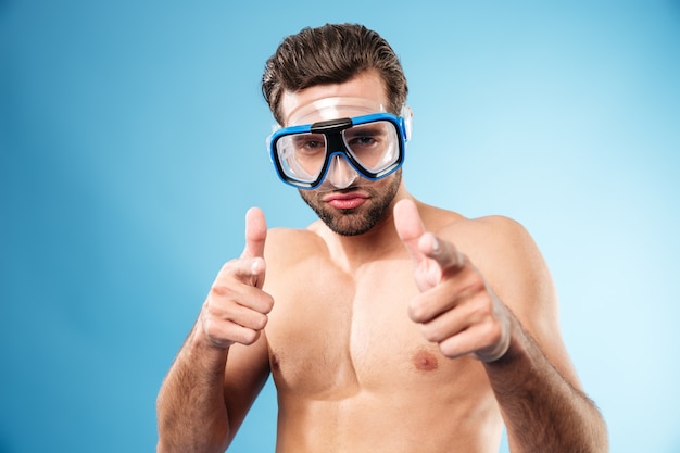 Man wearing swimming goggles and pointing two fingers