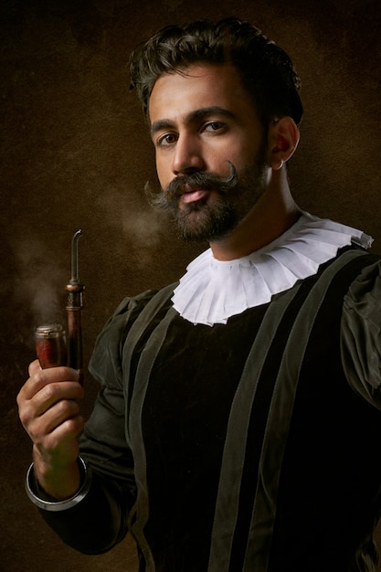 Бесплатное фото Человек в традиционной одежде и курительная трубка