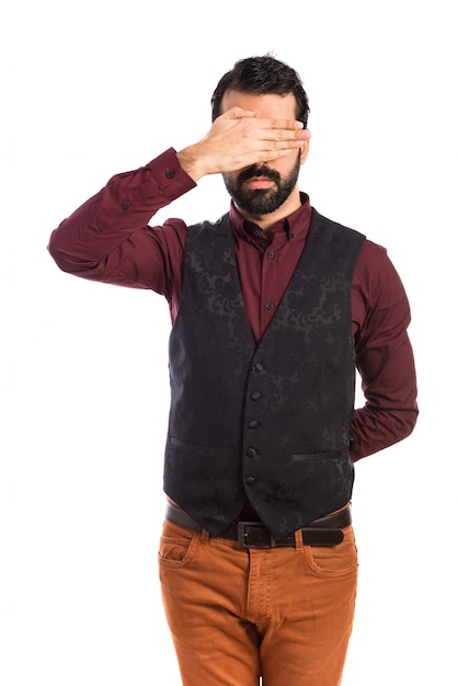 Man wearing waistcoat covering his eyes