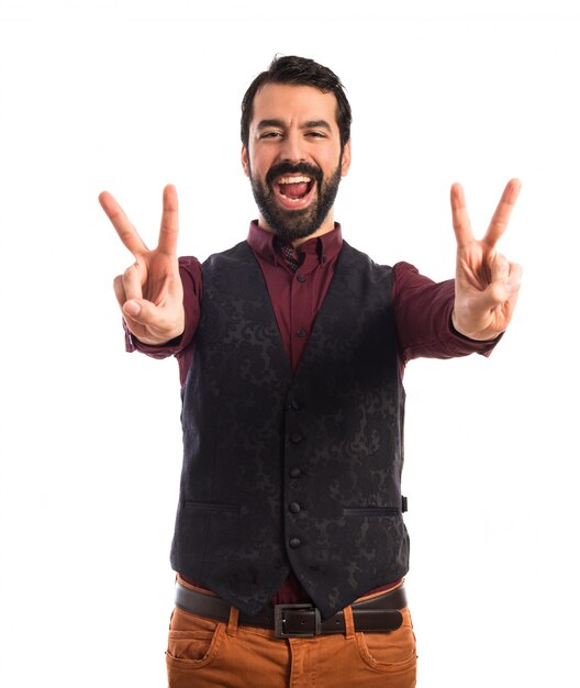 Man wearing waistcoat doing victory gesture