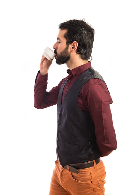 Man wearing waistcoat drinking coffee