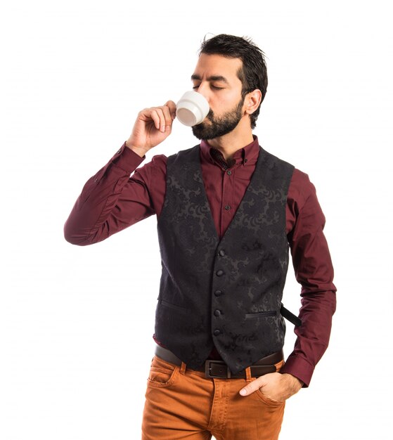 Man wearing waistcoat holding a cup of coffee