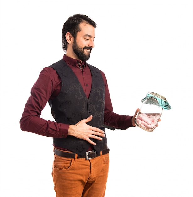 Foto gratuita uomo che porta un jar di vetro in panciotto con dolci dentro