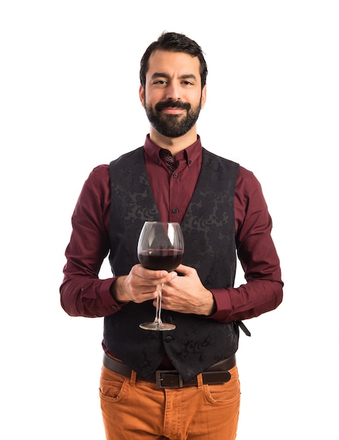 Uomo che indossa il panciotto che tiene un bicchiere di vino