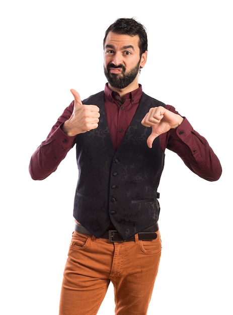 Free photo man wearing waistcoat making a good-bad sign