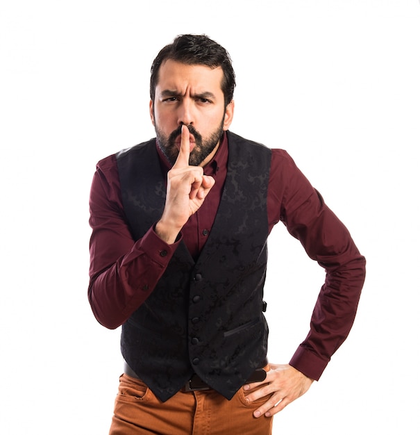 Man wearing waistcoat making silence gesture