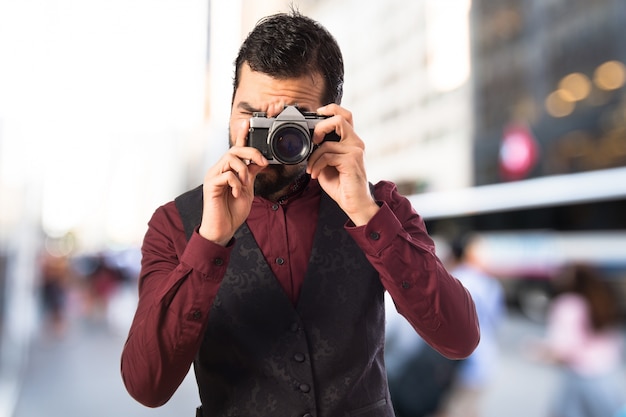 Free photo man wearing waistcoat photographing